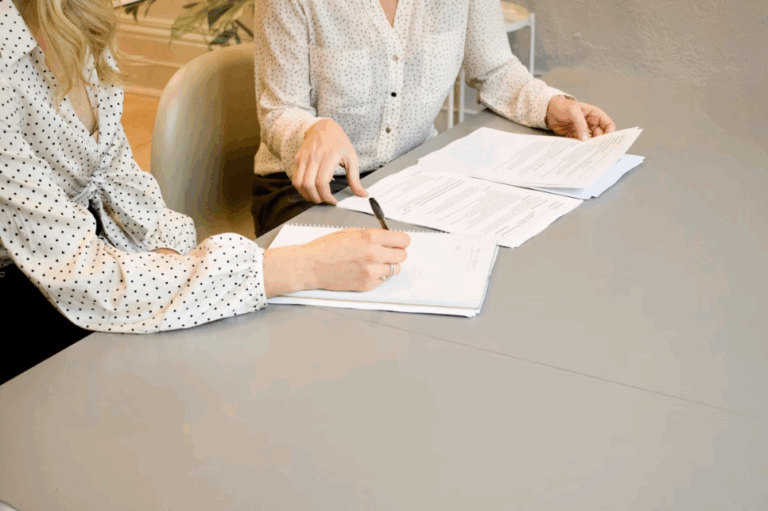 A woman signing documents for notarization.
