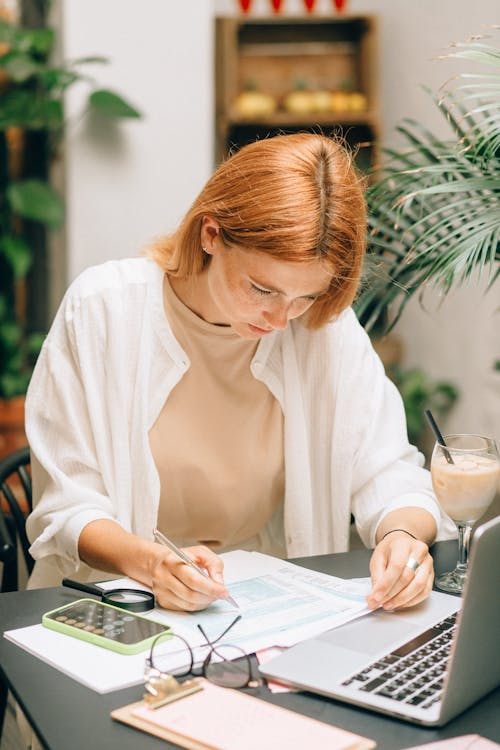 A desk with organized tax documents, calculator, and laptop prepared for financial review