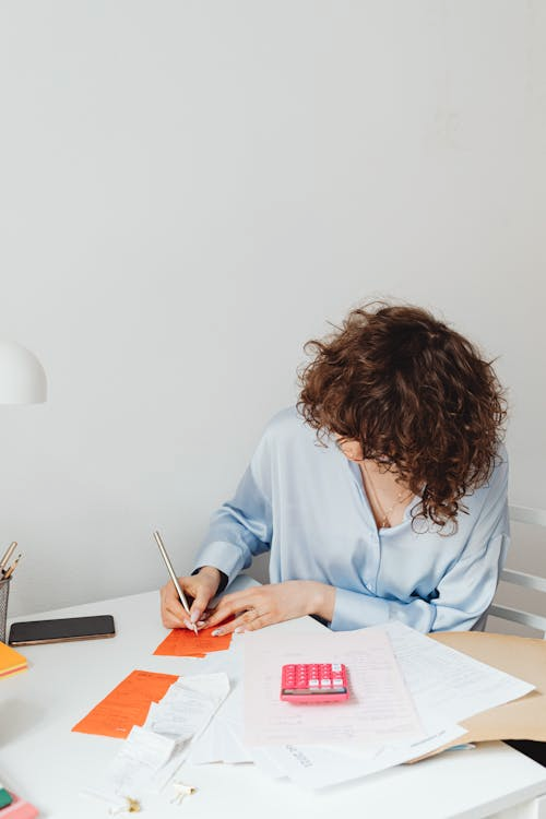 A person organizing tax forms and receipts at a desk.