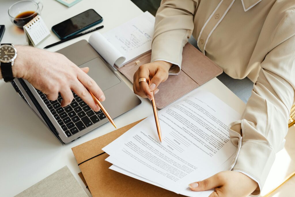 close-up of people pointing at a document with their pens
