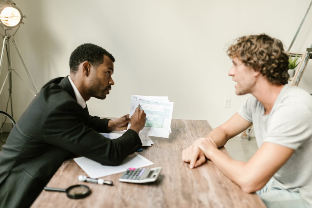 tax professional discussing financial documents with a client at an office desk