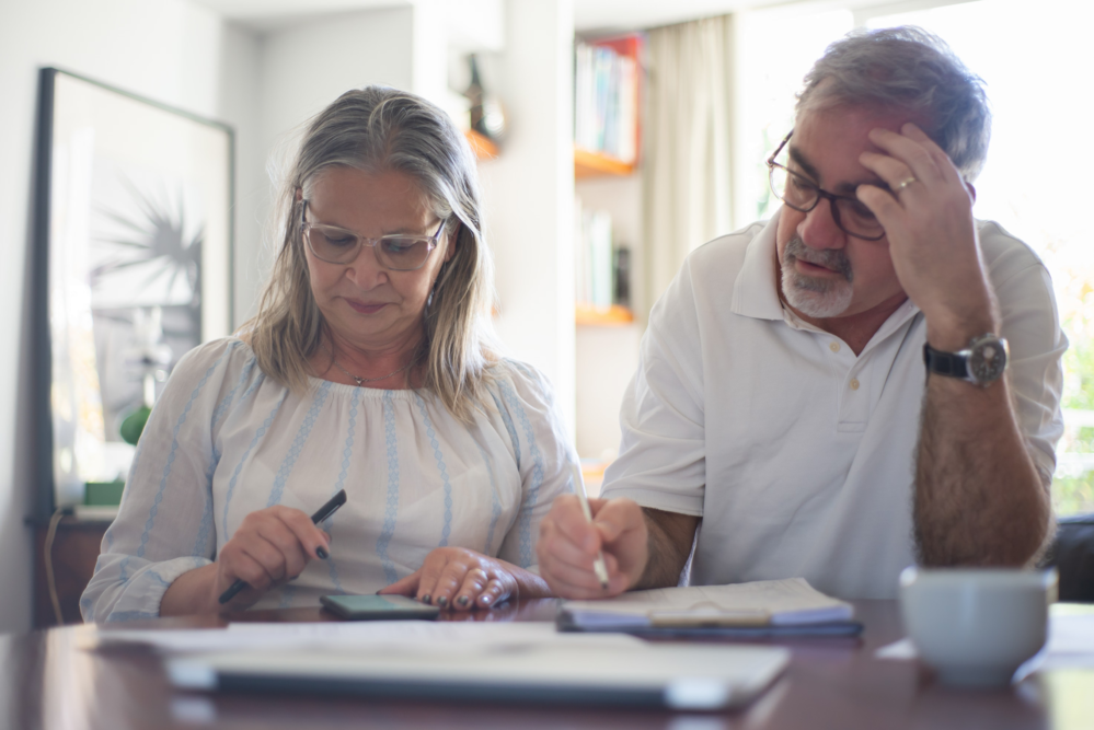 Senior couple discussing financial documents together at home