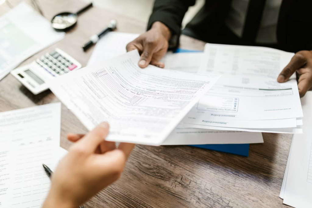 Tax professional reviewing financial documents with a client at a desk